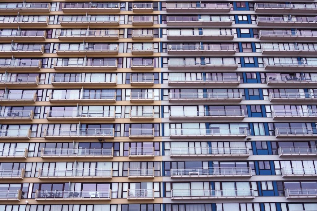 Symmetrical facade of a modern residential apartment building showcasing multiple balconies and windows.